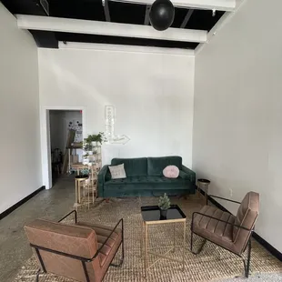 a living room with a green couch and chairs