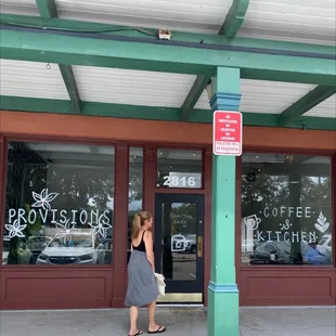 a woman walking past a storefront