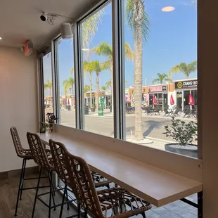 a long table with chairs in front of a large window
