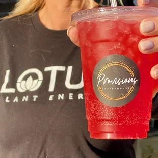 a woman holding a red drink