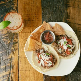 a plate of tacos and a drink