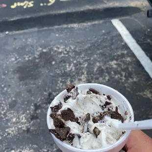 a hand holding a cup of ice cream