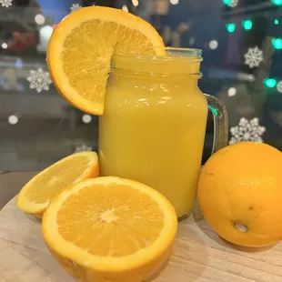 a glass of orange juice and sliced oranges