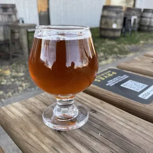 a glass of beer on a wooden table