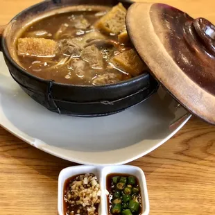 a bowl of soup and two small bowls of dipping sauce