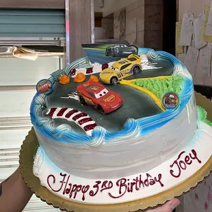 a hand holding a birthday cake