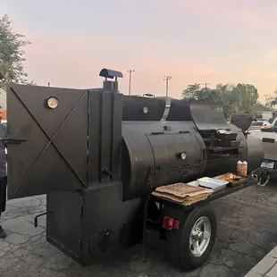 two men standing next to a bbqqqqqqqqqqqqq