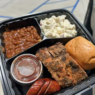 Sample plate with baby back ribs, grilled hot link, potato salad and bbq beans plus our original homemade bbq sauce