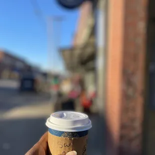 a hand holding a cup of coffee