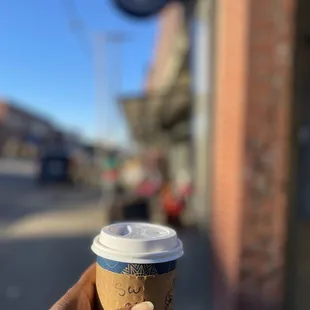 a hand holding a cup of coffee