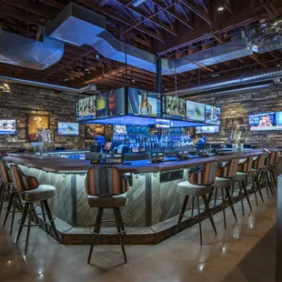 a bar with chairs and televisions