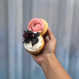 a hand holding a cupcake