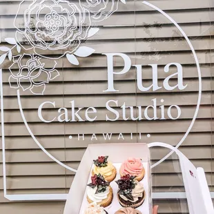 a person holding a box of cupcakes