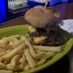 a hamburger and fries on a green plate