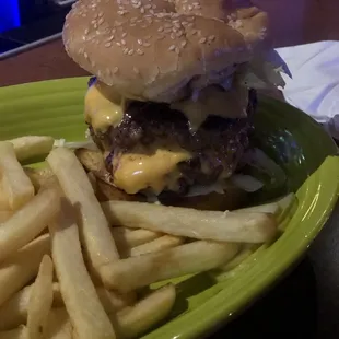 a hamburger and fries on a green plate