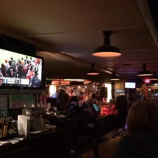 people sitting at the bar watching tv