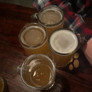 four beer glasses on a table
