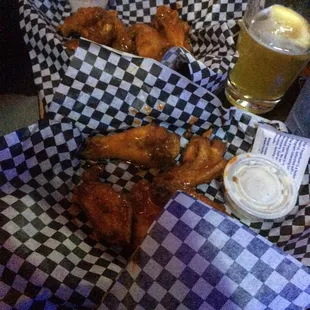 a basket of chicken wings and a glass of beer