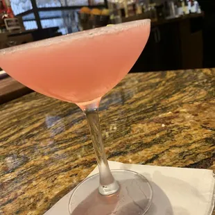 a pink drink in a glass on a napkin