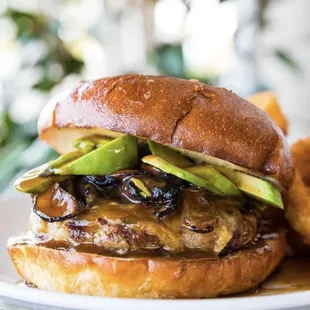 a burger with onions and avocado