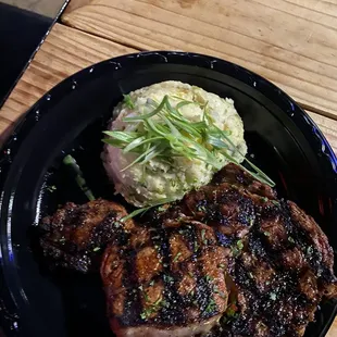 a plate of steak and mashed potatoes