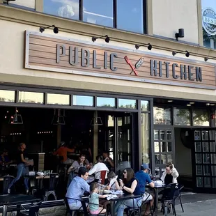 people sitting at tables outside a restaurant