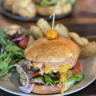 Cheeseburgers with salad and potato chips.