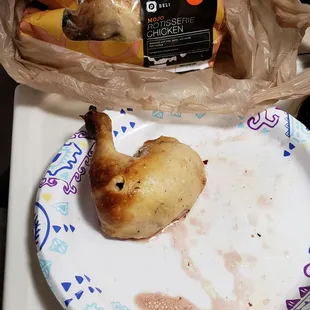 a half eaten chicken on a paper plate