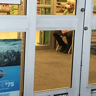a man sitting in a chair in front of a door
