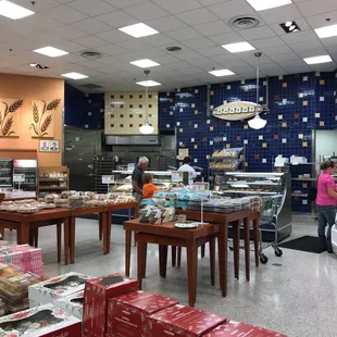 a woman in a pink shirt standing in front of a counter
