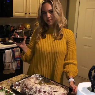 a woman in a yellow sweater holding a glass of wine