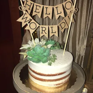 a cake with a banner and succulents