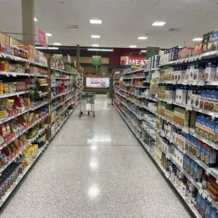 a grocery store aisle with a shopping cart