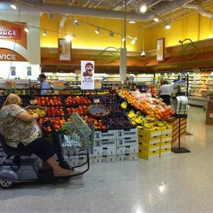 a woman in a shopping cart in a grocery store