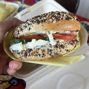Everything bagel with scallion cream cheese and added tomato and cucumber