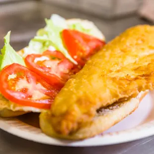 a fish sandwich with lettuce and tomatoes
