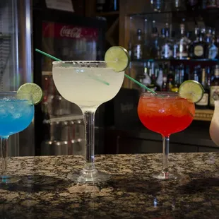 three cocktails on a bar