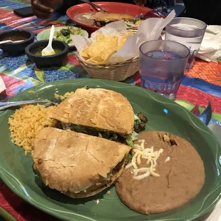 Carne Asada Torta Dinner with a side of chips, guacamole, salsa, and salsa verde.