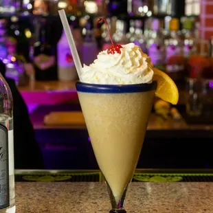 a margarita with whipped cream and a cherry garnish