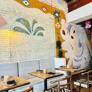 a restaurant with a mural on the wall
