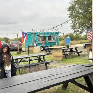 a woman standing in front of a food truck