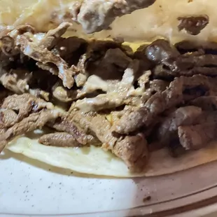 Steak Quesadilla has ground beef under steak,, very greasy bottom that oil comes out,, top steak is dry without seasoning