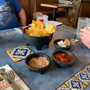 a table with chips and salsa