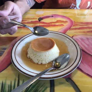 a plate of flan with a spoon