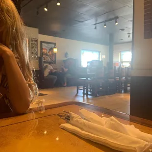 a woman sitting at a table in a restaurant