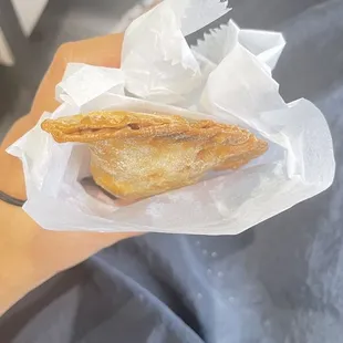 a hand holding a sandwich