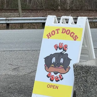 a hot dog open sign on the side of the road