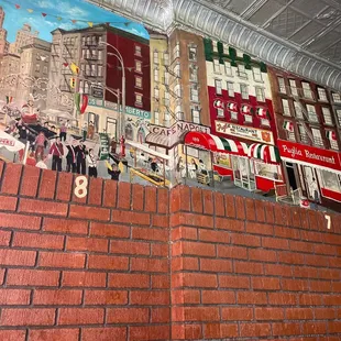 a brick wall with a mural on it