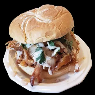 CLUCK!  Our pulled chicken sammich, served on a dusted kaiser bun with our Omaha (Alabama) White BBQ sauce