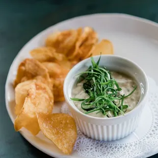 a bowl of dip and chips on a plate